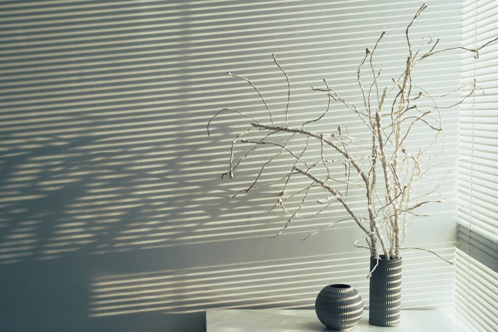 Vase with white tree branches at the wall