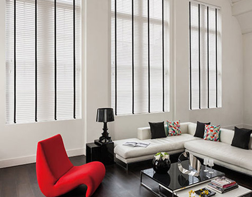 Black and white venetian blinds in a white living room with statement furniture