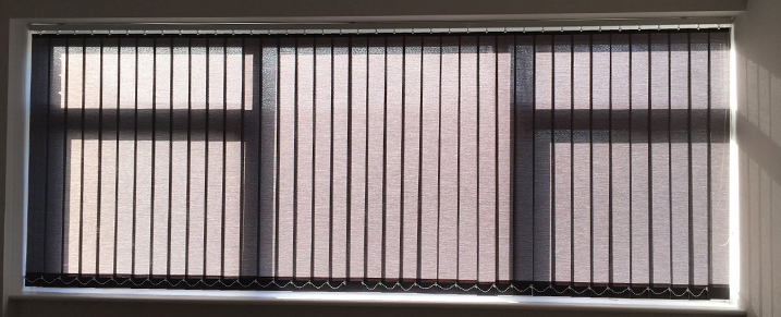 Grey vertical blinds on a big bay window