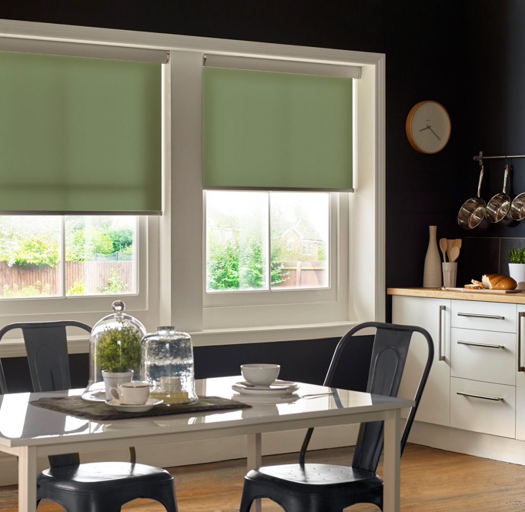 Window blinds Coventry. Green roller blinds in kitchen window. Dark walls and dining table.